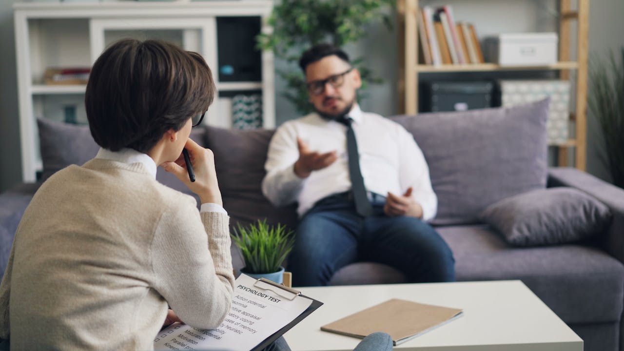 Therapist and client discussing problems in a modern office environment.
